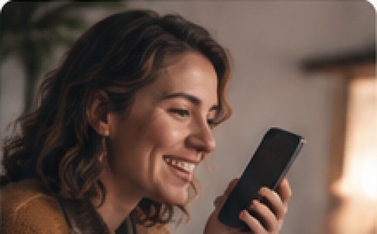 A woman smiling while talking into her phone